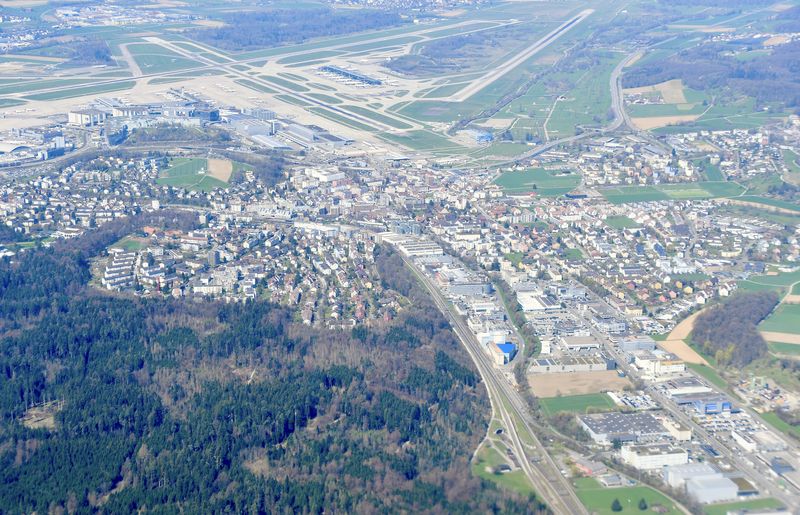 Luftaufnahme von Kloten mit dem Flughafen Zürich im Hintergrund