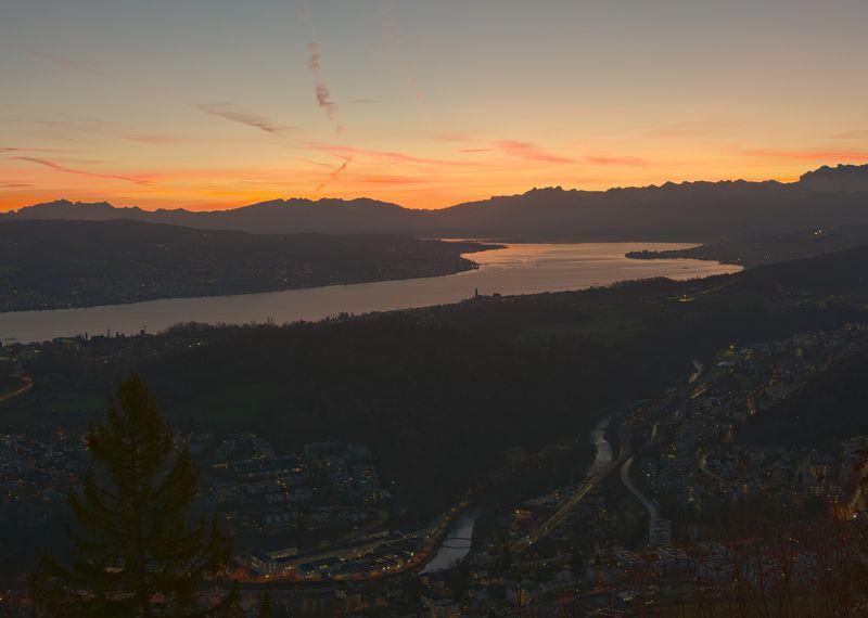 Blick über den Zürichsee auf die Alpen bei Sonnenuntergang