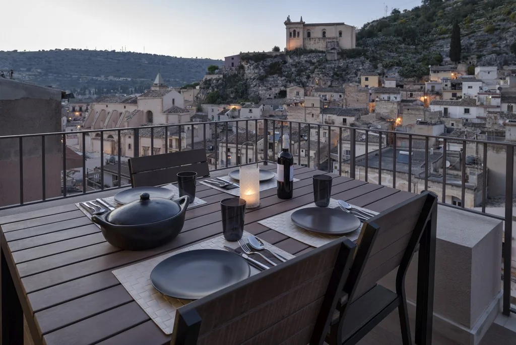 Terrace dining overlooking an Italian town at dusk